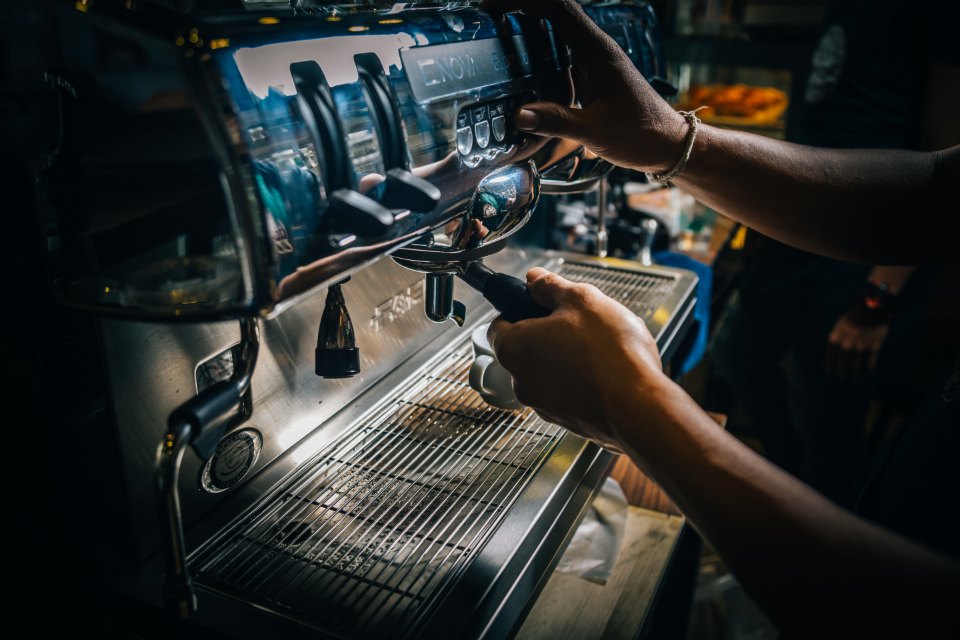 Barista připravuje espresso na pákovém kávovaru