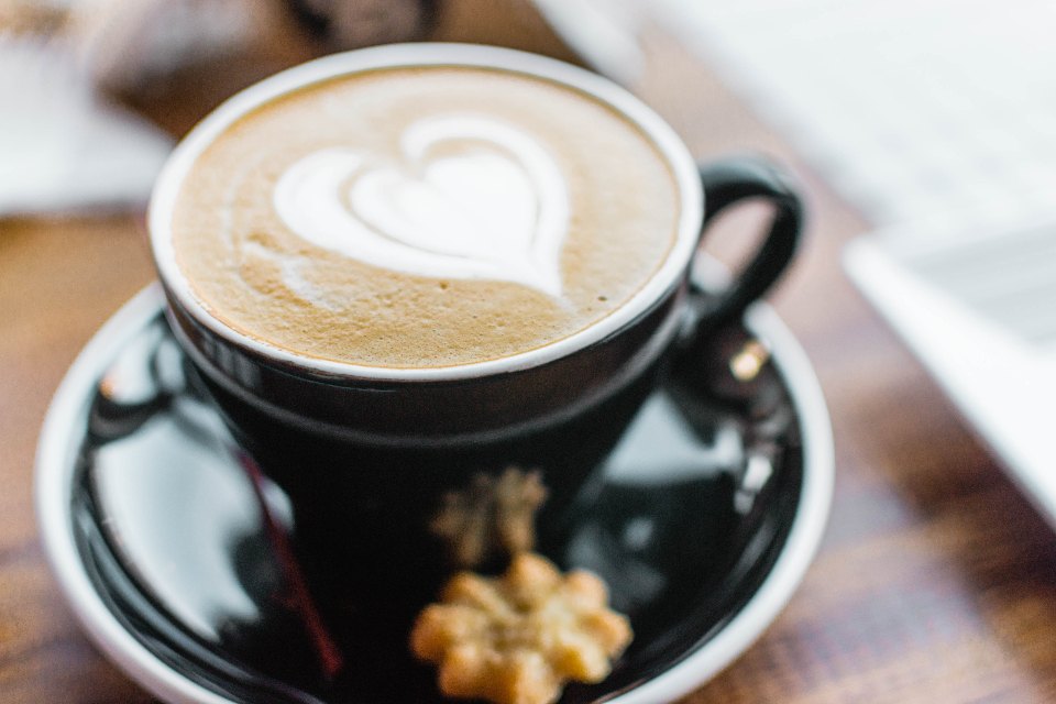 Cappuccino s latte art v tmavém šálku